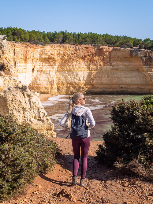 Me standing on a walking trail with steep yellow cliffs in the background.
