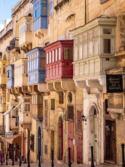 traditional colorful balconies decorating the limestone facades of old buildings in Valletta