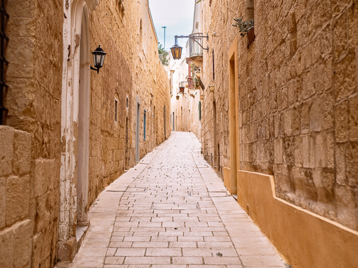 A narrow alleyway and limestone walls in the town of Mdina, a place that should be a part of every Malta itinerary