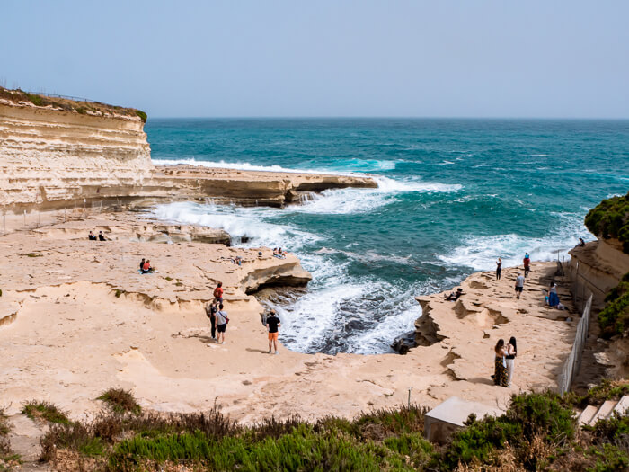 White cliffs and turquoise water at St. Peter's Pool, which is a sheltered cove and a popular swimming spot in Malta