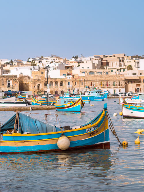 A wooden boat painted in blue and yellow in Marsaxlokk fishing village which is among the most Instagrammable places in Malta