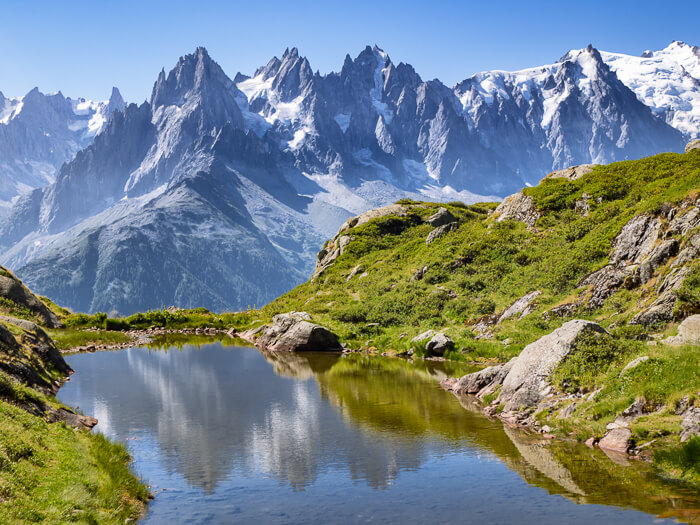 a small alpine lake reflecting the snow-capped peaks of the Mont Blanc massif near Chamonix