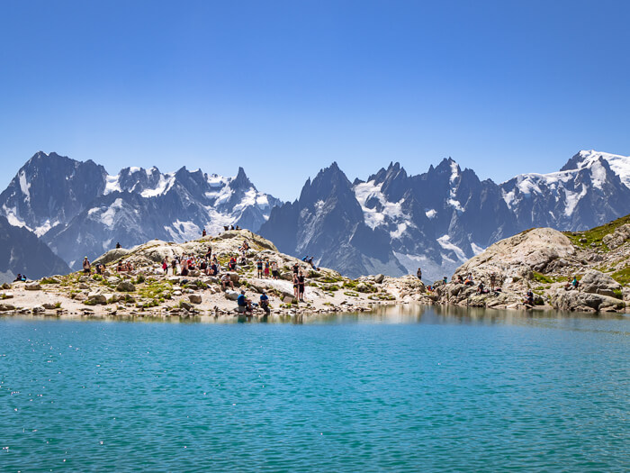 Turquoise water of the Lac Blanc lake surrounded by snowy mountain peaks near Chamonix, France