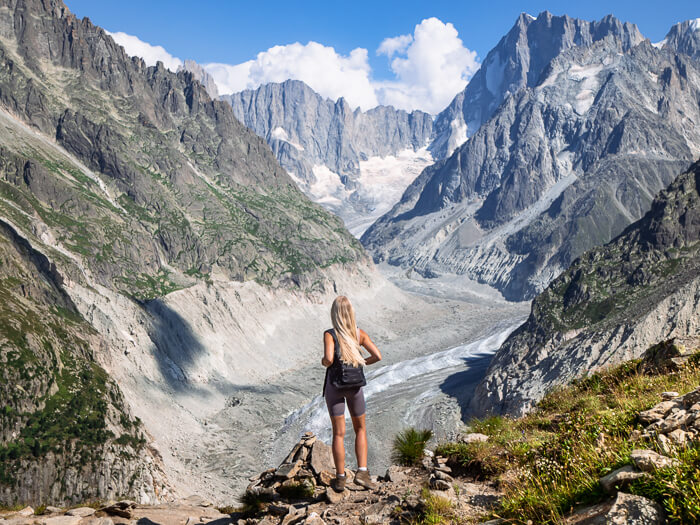 A woman looking at the panoramic view over the Mer de Glace glacier and the surrounding mountains at Signal Forbes viewpoint near Chamonix