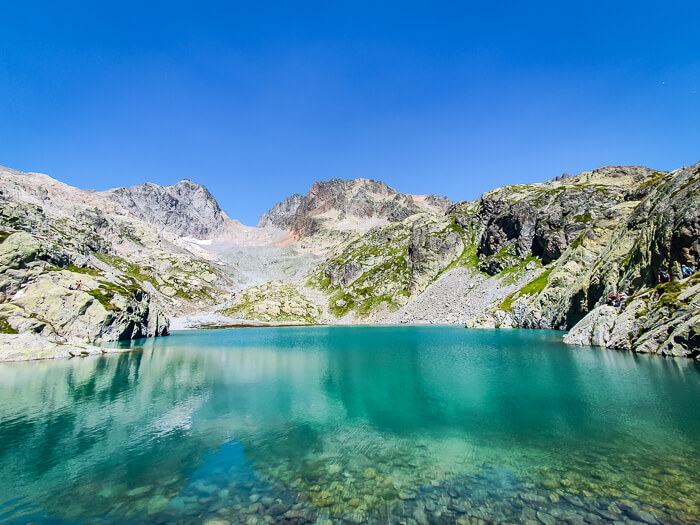 The vivid blue water of Lac Blanc surrounded by rocky shores