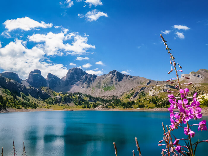 Calm glassy water surrounded by mountain peaks at Lac d'Allos, one of the best lakes to visit in France