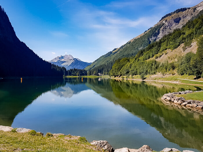 Mountain scenery and smooth water at Lake Montriond which is a popular swimming lake in the summer