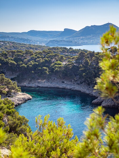 A narrow bay with turquoise water nestled between limestone cliffs in Calanques National Park on the Mediterranean coast of France.