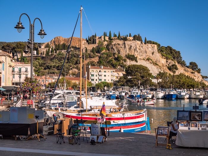 A colorful wooden sailing boat at the busy harbor of Cassis, a popular seaside town in Southern France.