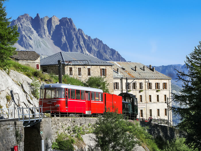 an old red cogwheel train and a historical mountain hotel at Montenvers near Chamonix