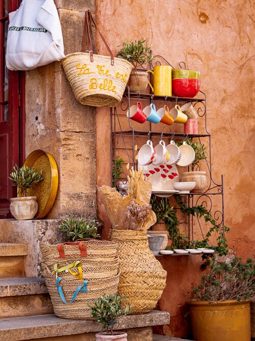 Colorful pottery and accessories displayed in front of a small boutique in Roussillon village in Luberon region