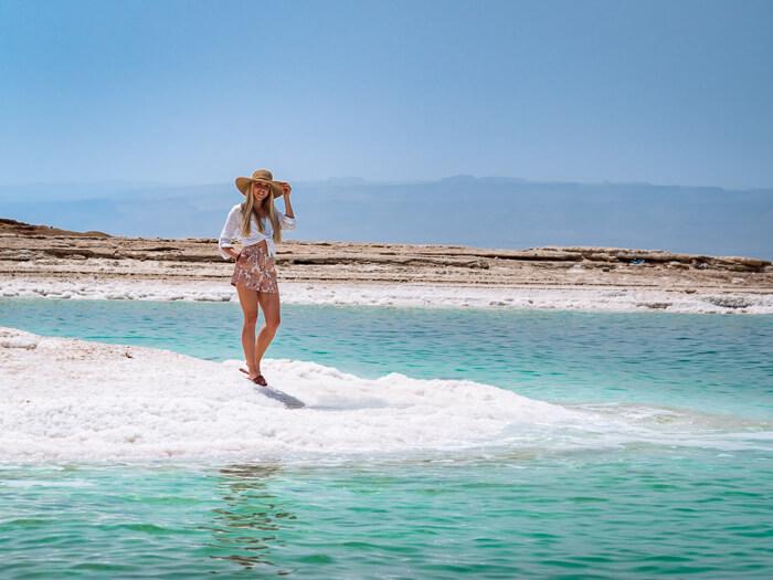 Me standing on a beach covered in salt crystals at Dead Sea, one of the best places to visit on this 10-day Jordan itinerary