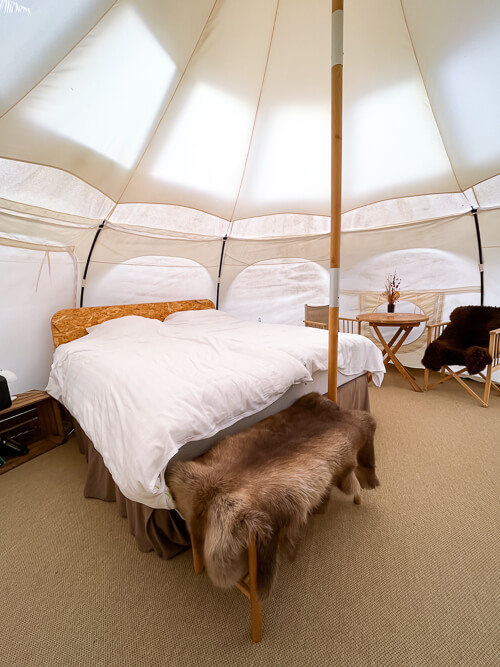 A double bed and rustic furniture in a luxury glamping tent at Thorseng Nature Resort