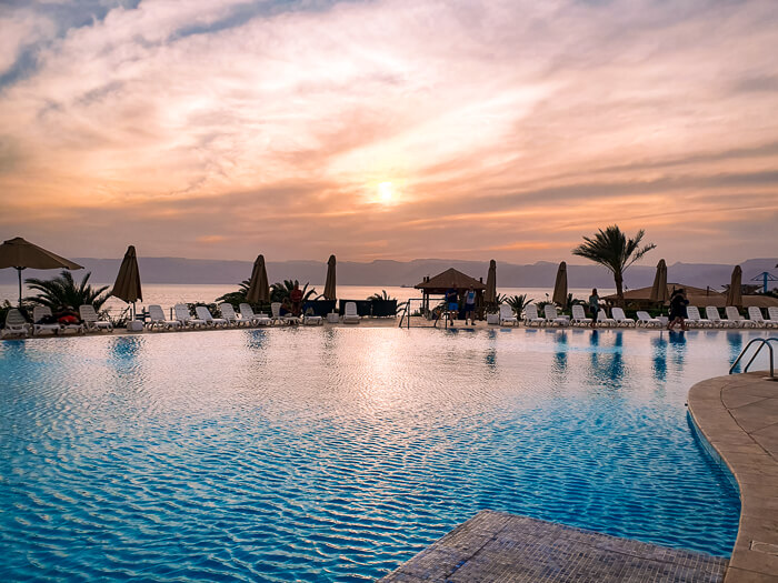 sunset reflecting on a large pool in Berenice Beach Club in Aqaba, an excellent place to relax at the end of your Jordan itinerary