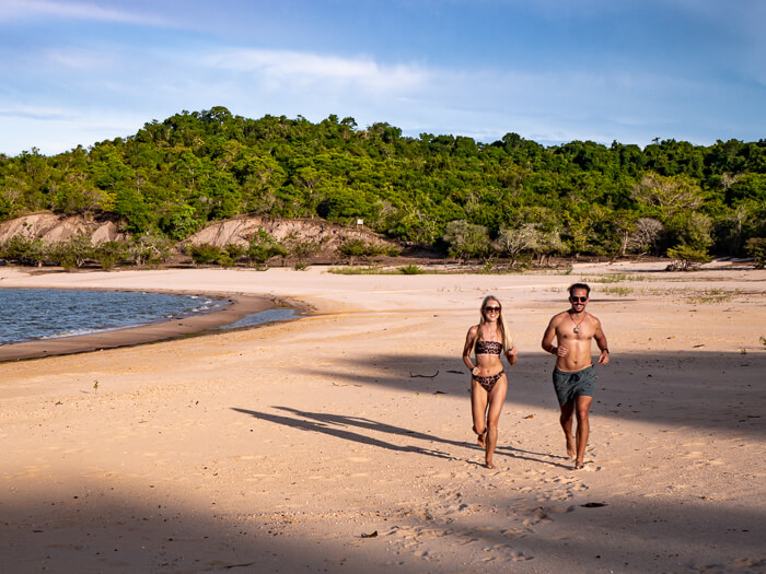A couple running on a sandy deserted beach near Alter do Chão, the state of Para