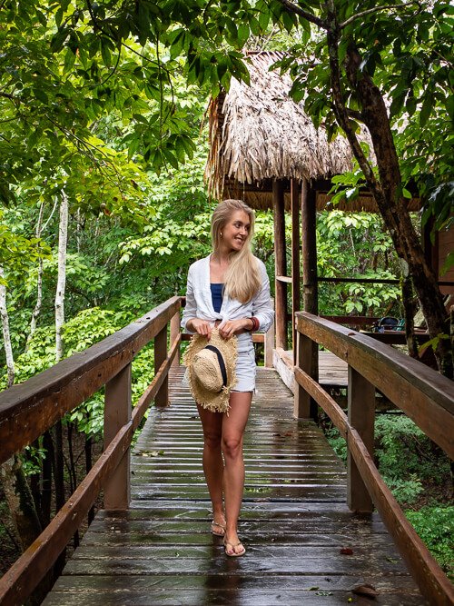 A woman standing on a wooden terrace in front of a jungle lodge near Manaus