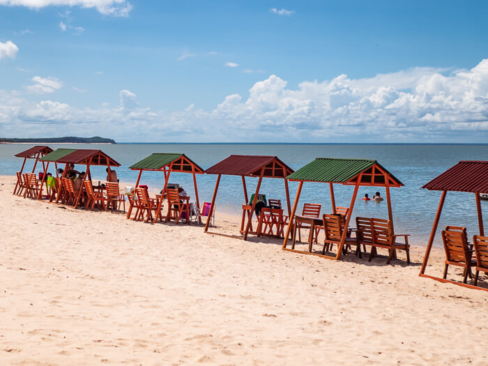 A row of orange beach chairs along the beach near Santarem, Para.