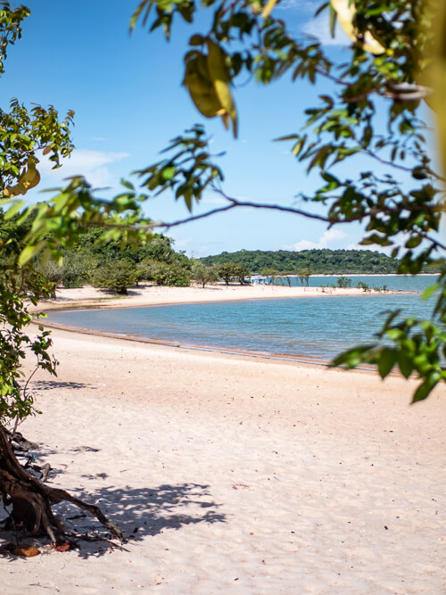 a deserted white sand beach with calm blue water on Ilha do Amor in the Amazon region in Brazil