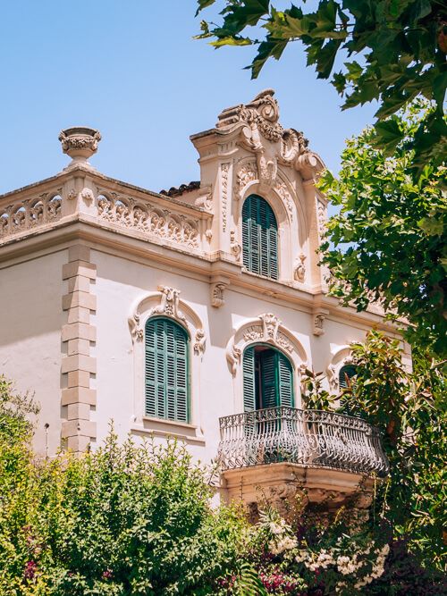 A historical building with green shutters and intricate details in Soller.