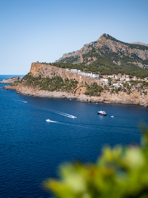 The mountainous Port de Soller coastline with white houses perched on the edge of a cliff.