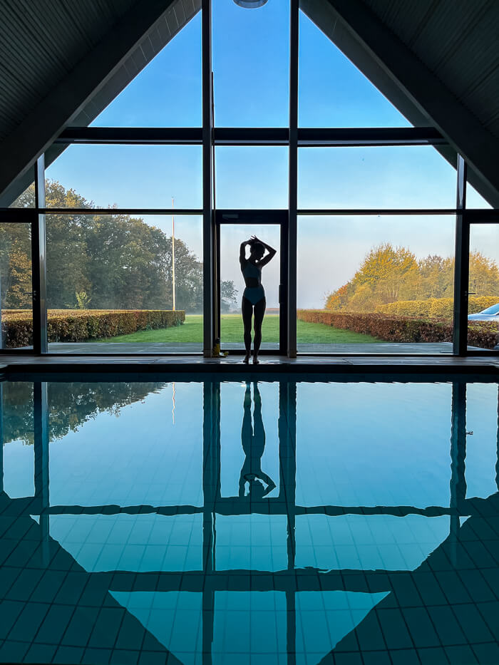 a silhouette of a woman standing next to a pool at Thorseng Nature Resort at South Funen