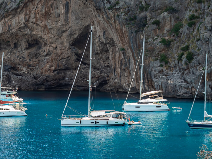 White sailing boats docked in bay; sailing is one of the top things to do in Cala d'Or
