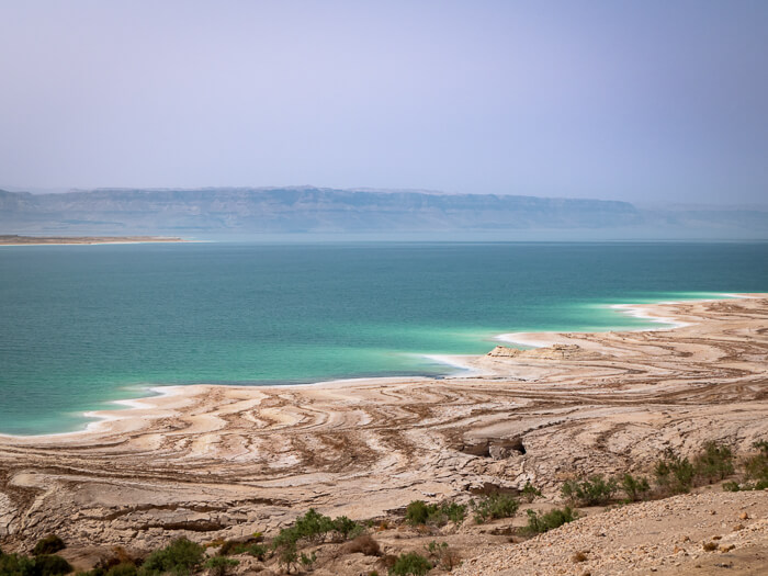 Turquoise water and white shores along the Dead Sea Highway, one of the best places for driving in Jordan