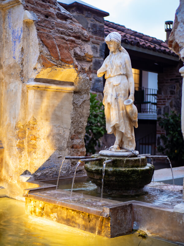 An old marble sculpture on top of a fountain at Hotel Casa Santo Domingo