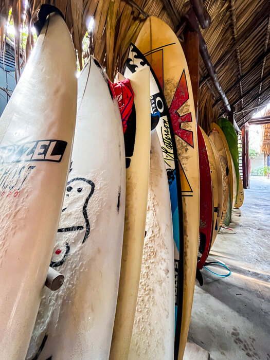 a row of colorful surfboards stacked against each other at a surf hotel