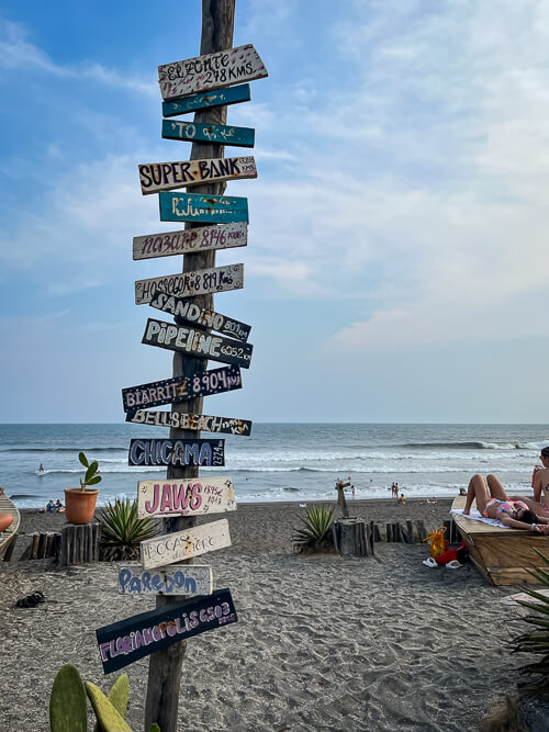 A signpost full of colorful signs on El Paredon Beach