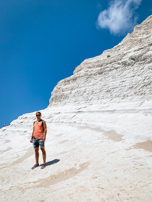 A man standing on the white cliff of Scala dei Turchi in Sicily