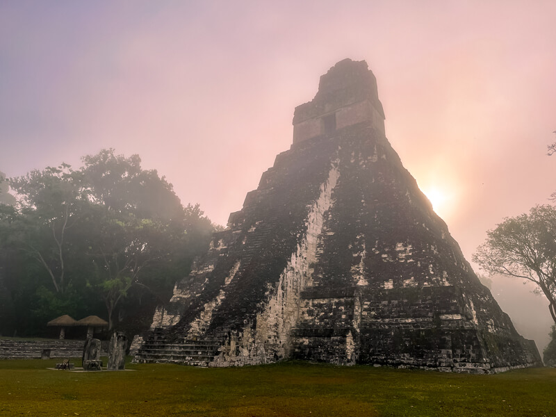 A Mayan temple surrounded by haze in the early morning in Tikal