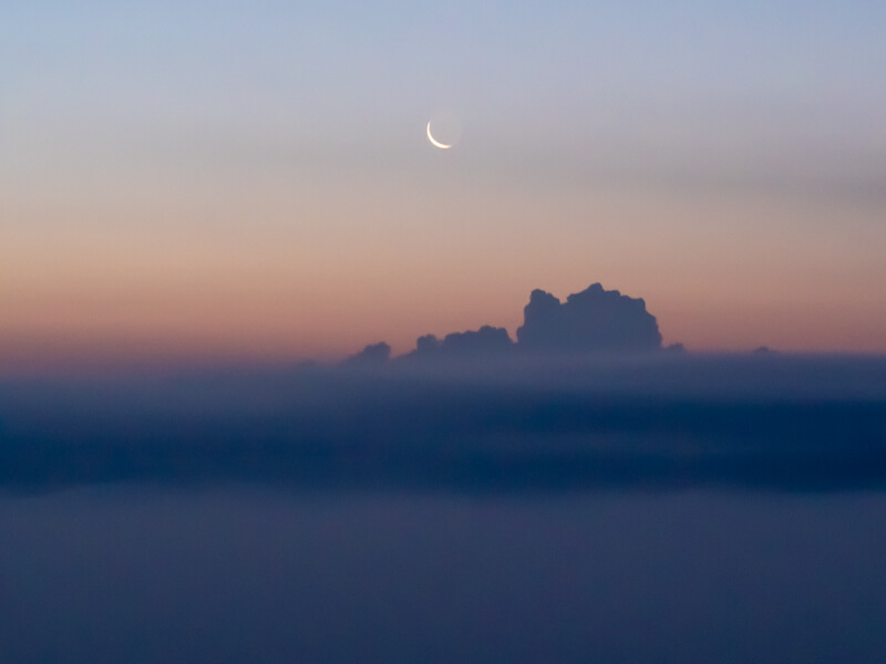 a moon and pink sky during sunrise in Tikal