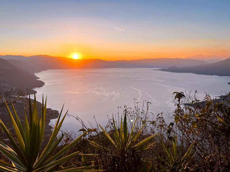 Bright orange sun rising from behind the mountains of Lake Atitlan, viewed from Nariz de Indio peak