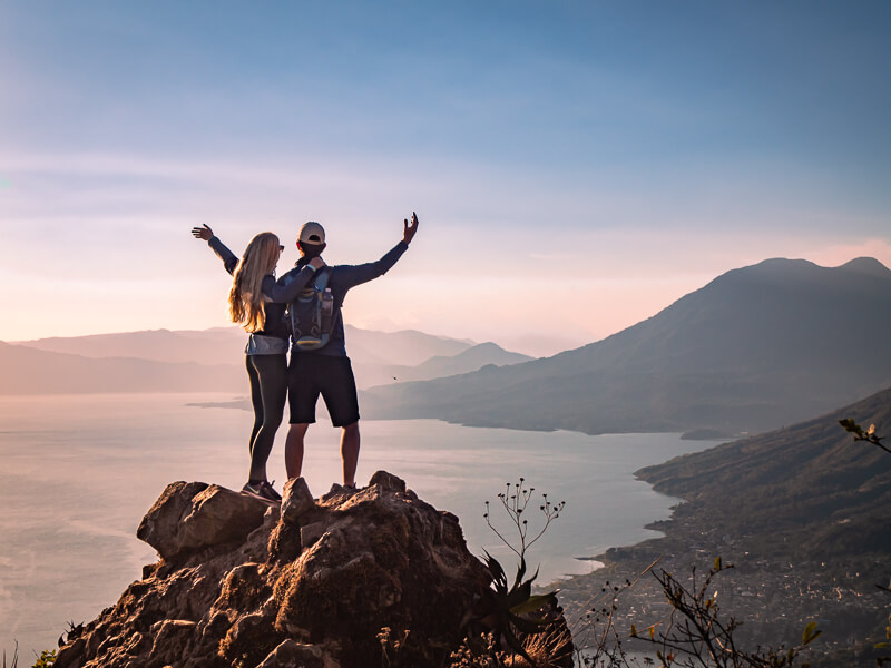 A couple posing on top of a large rock on the mountain of Indian Nose Atitlan