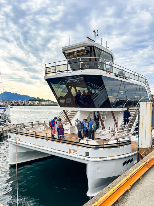 A two-level electric Brim Explorer catamaran docked in Svolvær harbor