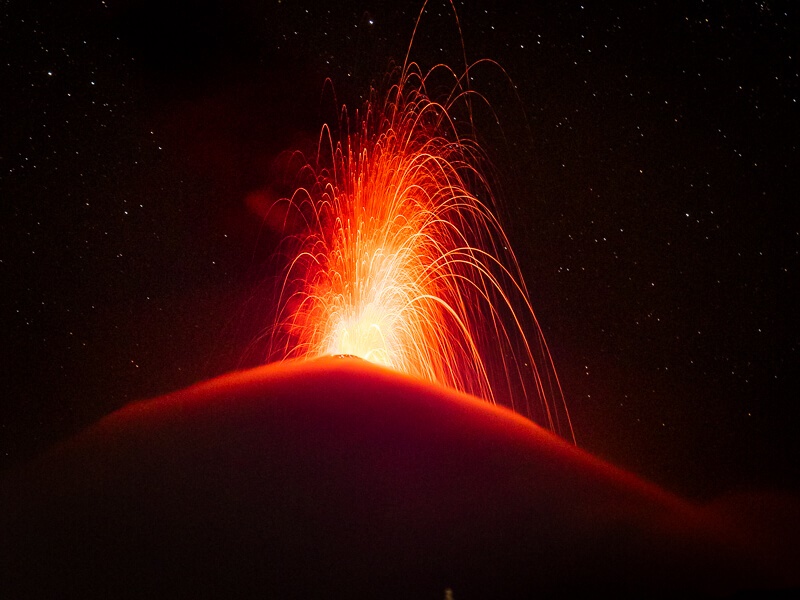 glowing red lava erupting from Fuego Volcano during the night