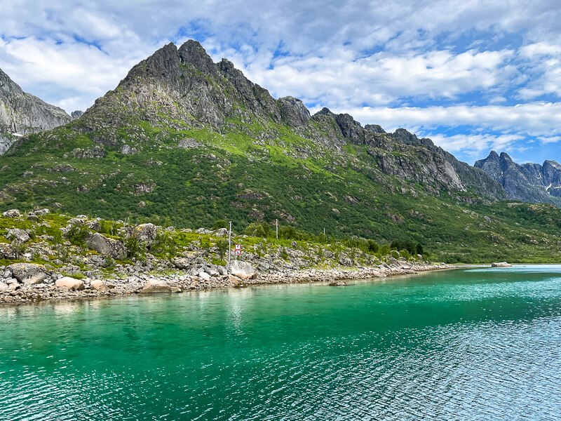 vivid turquoise sea and dramatic coastal mountains on the Lofoten Islands