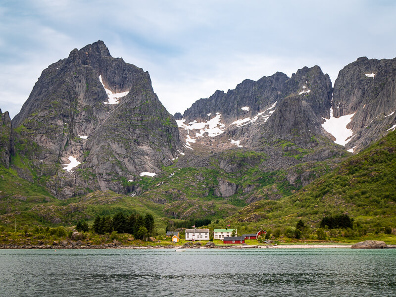 Towering mountain peaks dotted with patches of snow at the Raftsundet strait