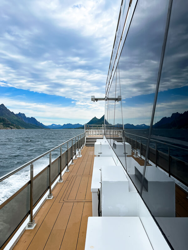 Reflections of sky on the large panoramic windows of Brim Explorer boat cruising through Lofoten