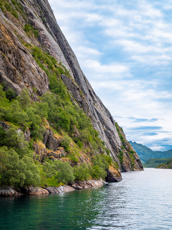 Vertical rock walls rising out of the sea at the mouth of Trollfjord, Lofoten