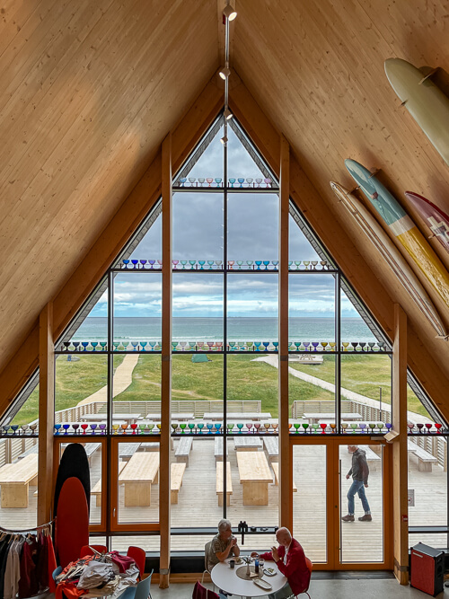 A large triangle-shaped window of the cafe at Lofoten Beach Camp