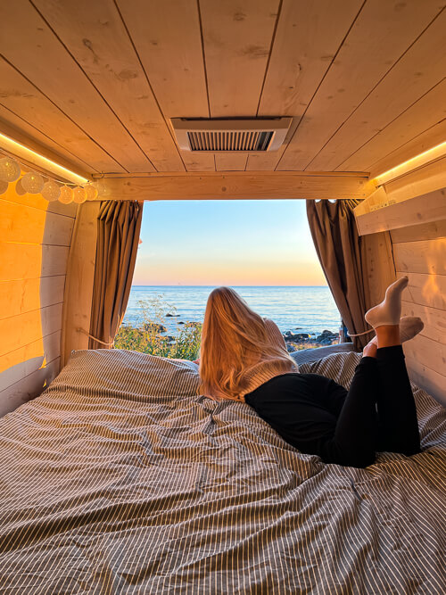 Me lying on the bed of the campervan that we rented from Wecamp in Norway.