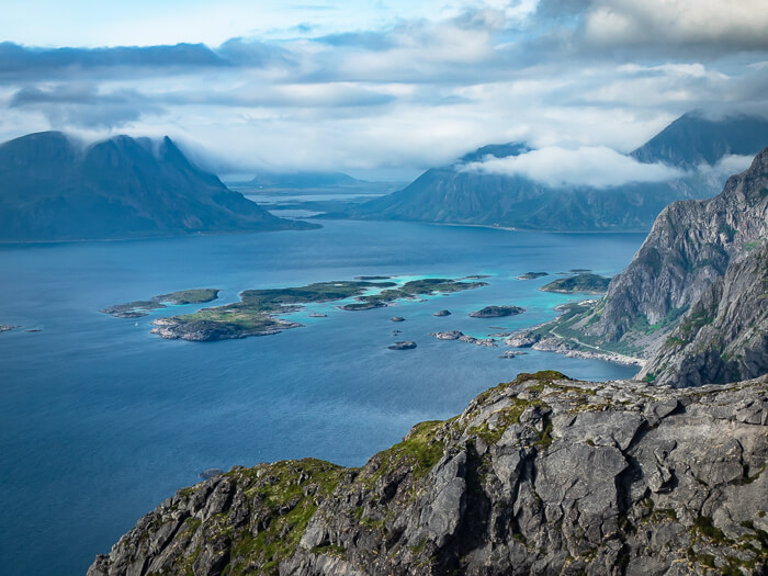 Small islands and steep craggy mountains rising straight from the sea, viewed from Festvågtind peak, one of the best hikes in Lofoten