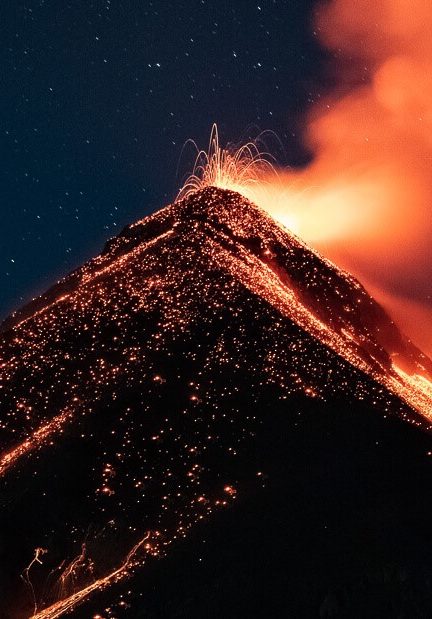 A volcano erupting with bright orange lava pouring down its sides