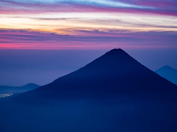 The conical Agua Volcano with pink sky in the background during sunrise