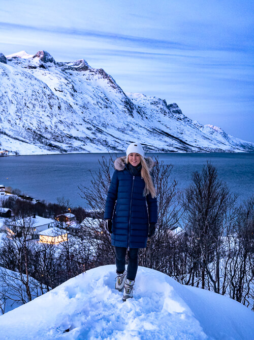 me standing on a snowy hill with the mountains around Ersfjord in the background