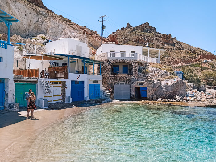 A small bay surrounded by white boat houses in the traditional fishing village of Firopotamos on the north coast of Milos island