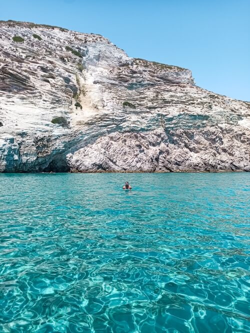 Vibrant blue water and white vertical rock walls at Gerakas Beach in Milos