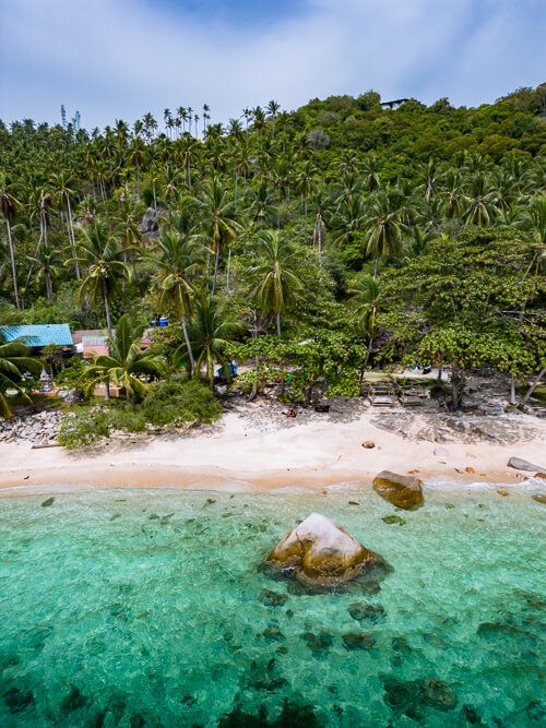 An aerial drone photo of the vibrant blue water and white sand of June Juea Beach, one of the highlights of this Koh Tao itinerary